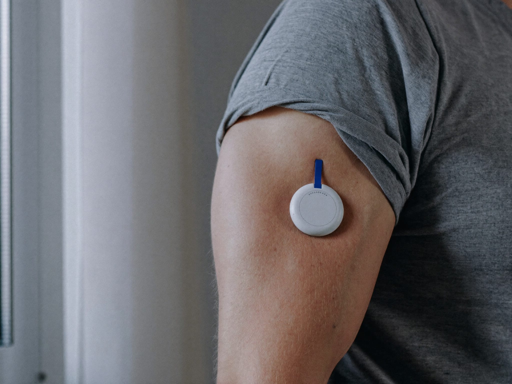 Continuous glucose monitor sensor worn on the back of an upper arm